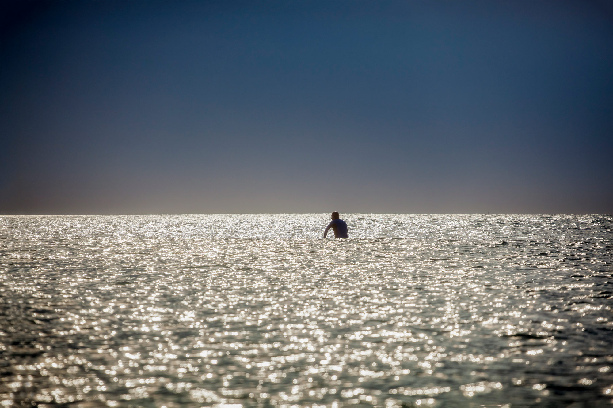 Texas surfer sits alone on his board in the water