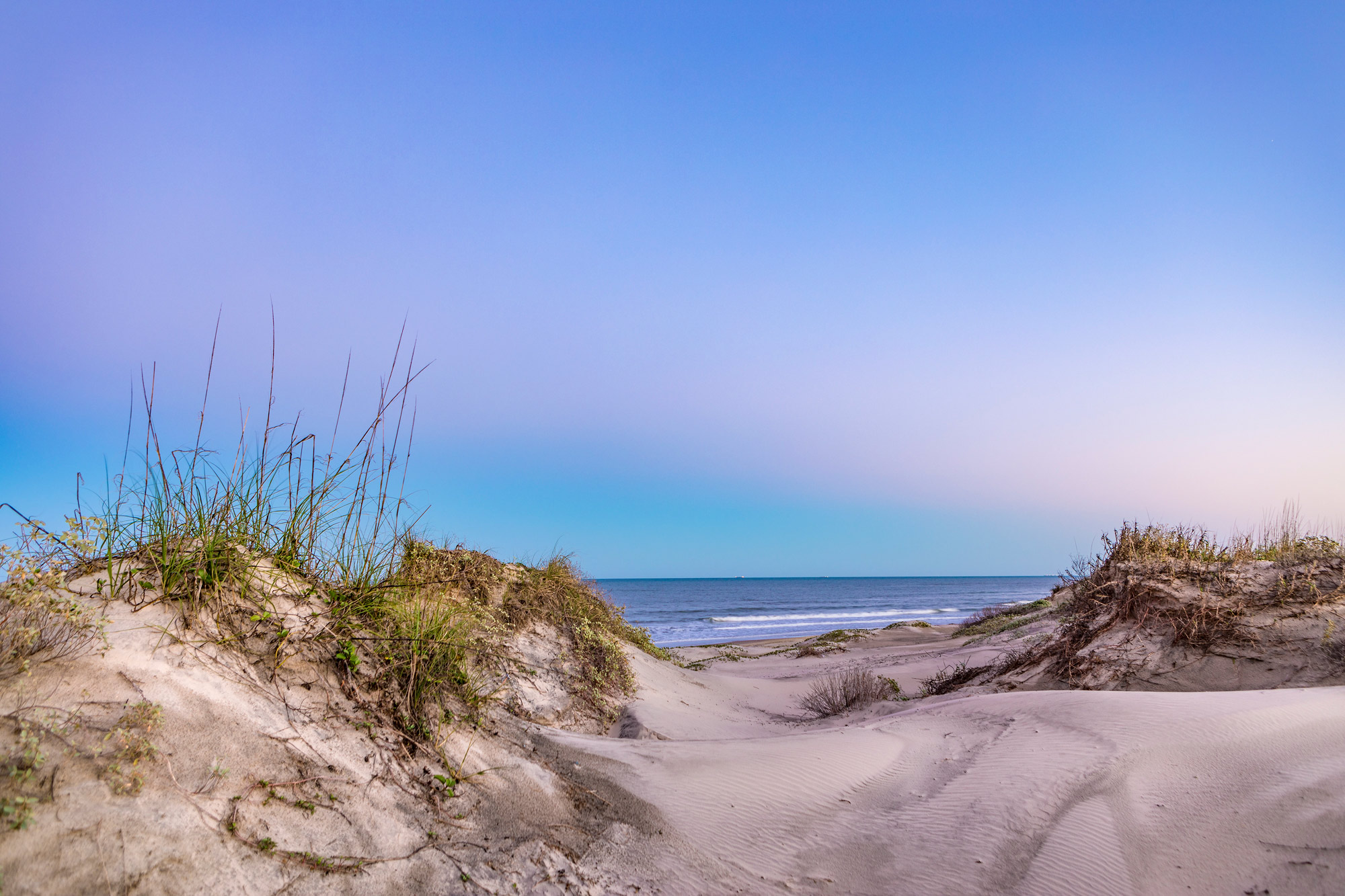 Sand dune with pink and blue sky at twilight
