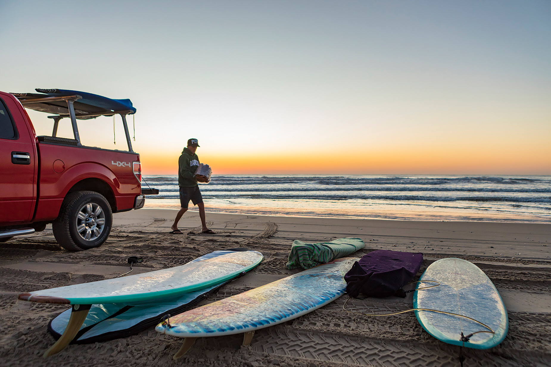 Texas surfer with surfboards and truck on the beach 