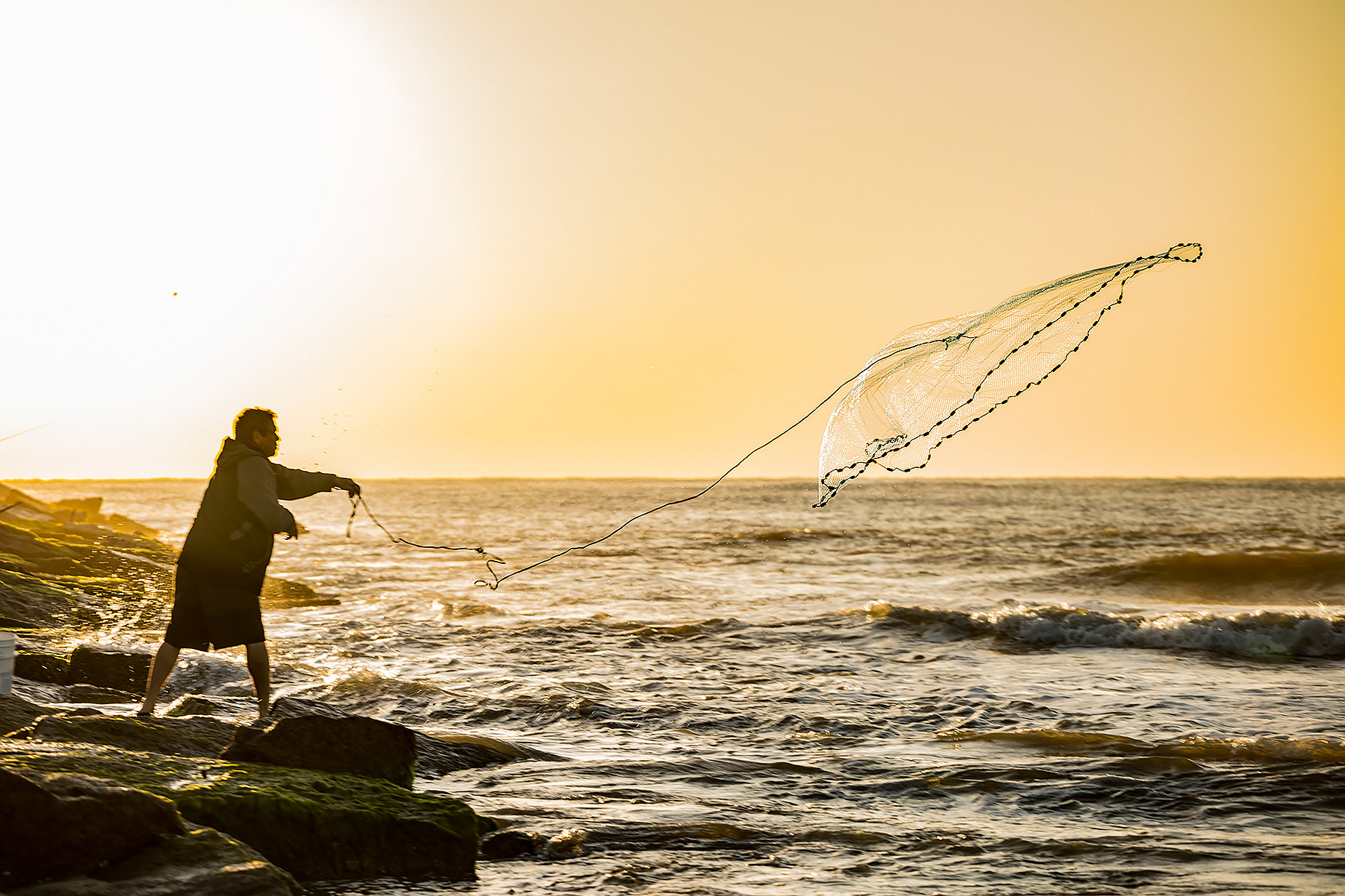 Fisherman with throw net on jetties in Texas