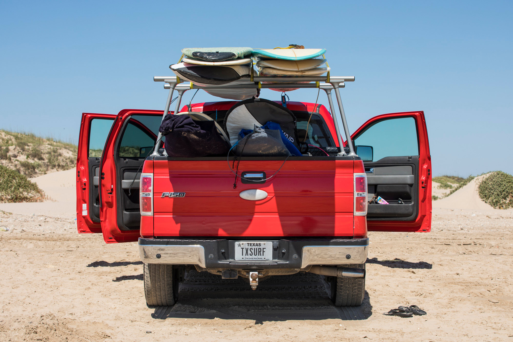 Red Texas Ford truck with surfboards